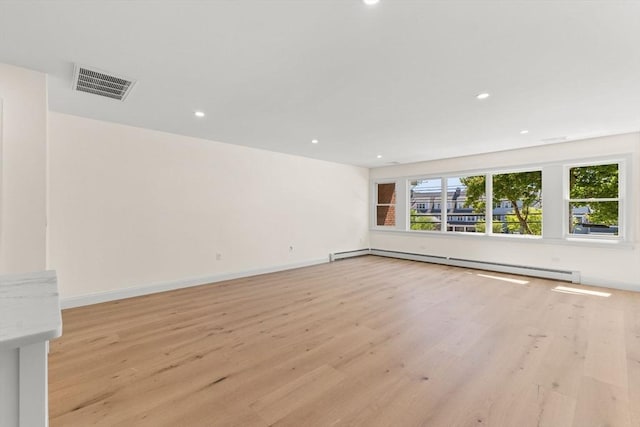 unfurnished living room featuring baseboard heating, light wood-style flooring, recessed lighting, and baseboards