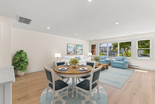 dining room featuring light wood-style flooring, recessed lighting, a baseboard heating unit, and baseboards