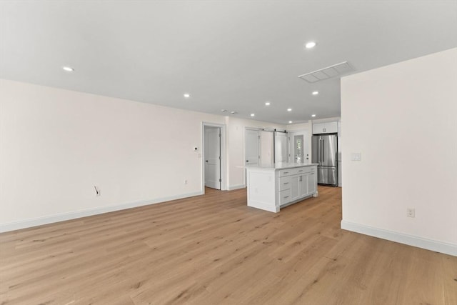 unfurnished living room featuring light wood-style floors, baseboards, and recessed lighting