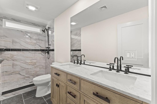 full bathroom with toilet, double vanity, and a tile shower