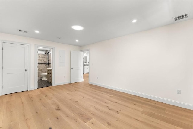 unfurnished bedroom featuring baseboards, light wood-style flooring, ensuite bath, and recessed lighting