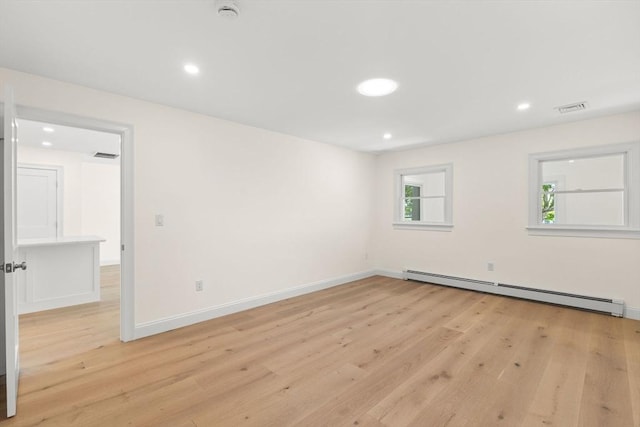 empty room with baseboard heating, light wood-style flooring, a smoke detector, recessed lighting, and baseboards