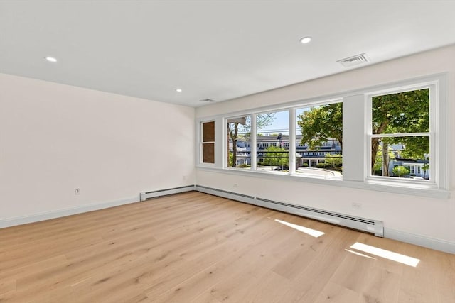 spare room with wood finished floors, a baseboard radiator, recessed lighting, and baseboards