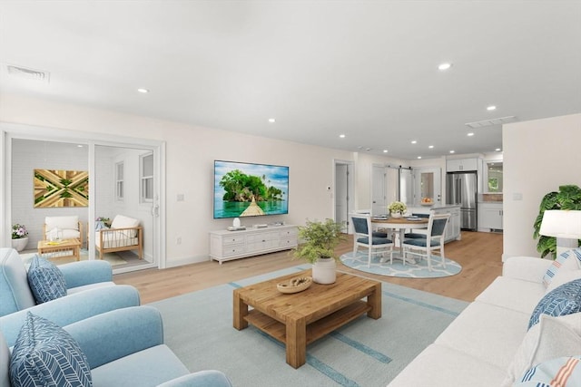 living area featuring light wood-style flooring and recessed lighting