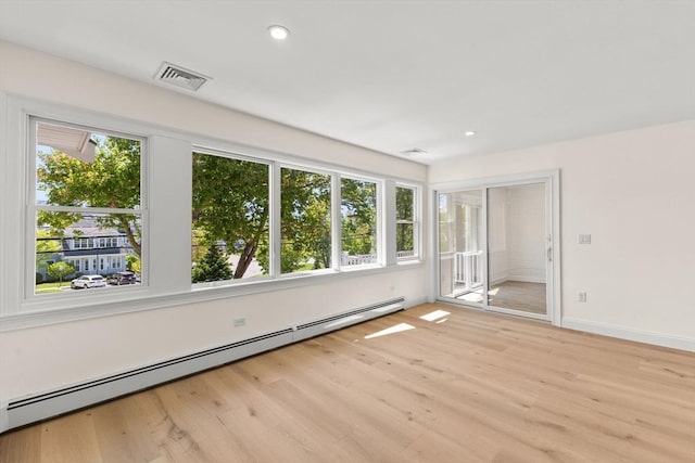 spare room with a baseboard heating unit, light wood-style floors, baseboards, and recessed lighting