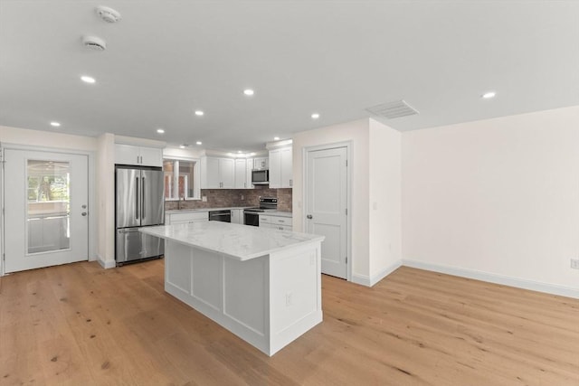 kitchen with stainless steel appliances, light wood-style floors, white cabinetry, and recessed lighting
