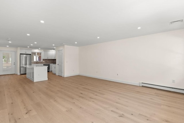 unfurnished living room featuring light wood-style floors, recessed lighting, baseboards, and baseboard heating