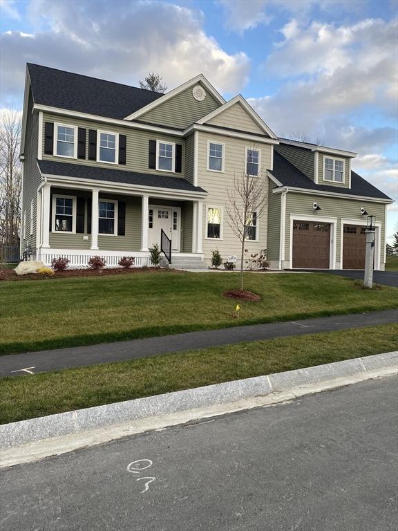 view of front facade featuring a garage, a front yard, covered porch, and driveway