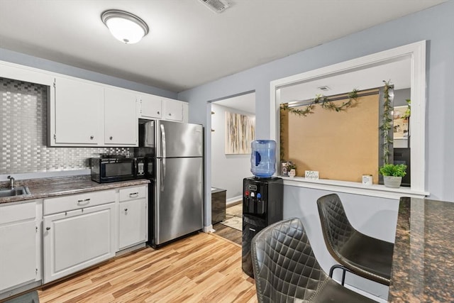 221 Oak St Unit 223, Brockton, MA 02302 - kitchen featuring freestanding refrigerator, black microwave, light wood-style flooring, dark countertops, and white cabinets