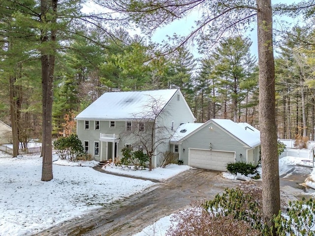 colonial home featuring driveway, a chimney, and an attached garage