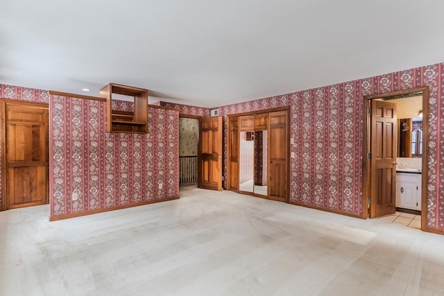 unfurnished living room featuring light carpet, baseboards, visible vents, and wallpapered walls