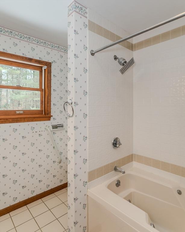 full bathroom with washtub / shower combination, tile patterned floors, and wallpapered walls