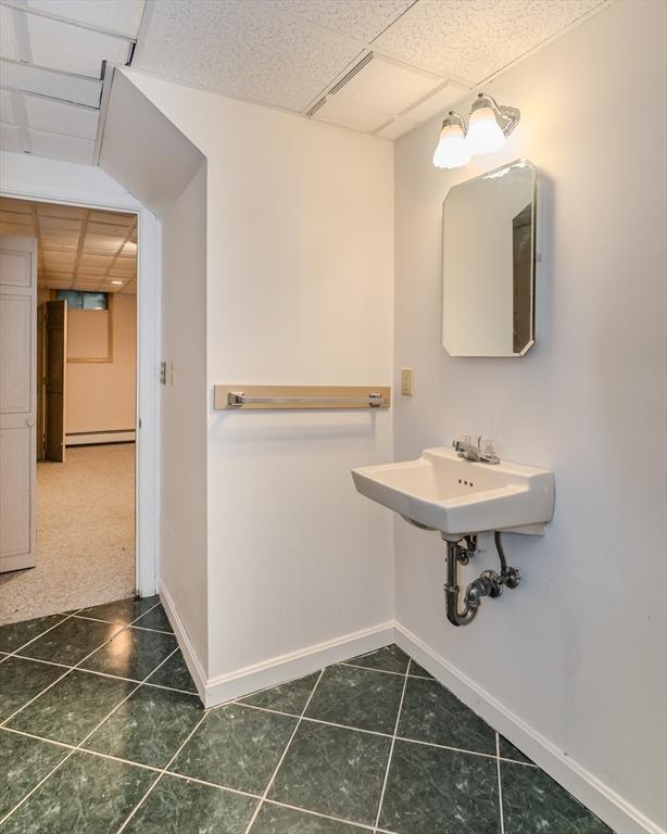 bathroom featuring baseboards, baseboard heating, a drop ceiling, and tile patterned floors