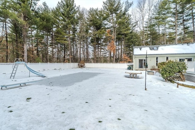 snowy yard featuring a fenced backyard