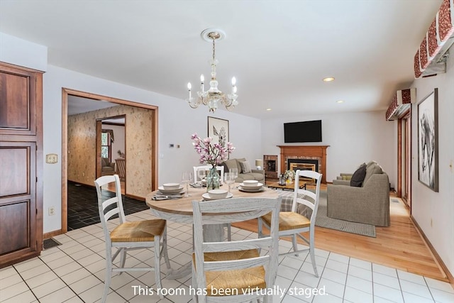 dining room featuring light tile patterned floors, a chandelier, recessed lighting, a fireplace, and baseboards