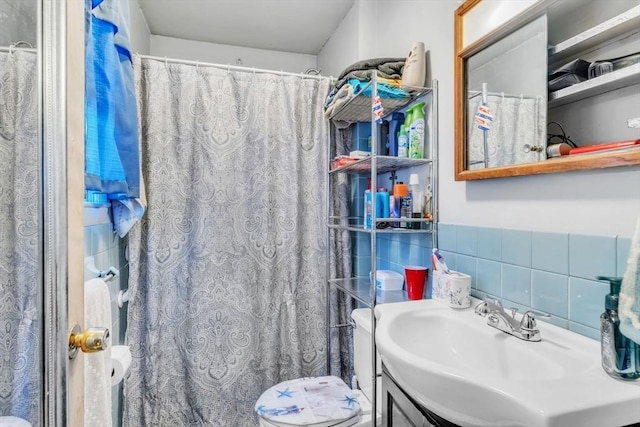 bathroom featuring sink, tile walls, curtained shower, and toilet