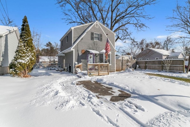 snow covered back of property featuring a wooden deck