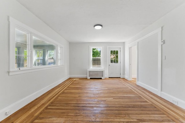 515 Front St, Weymouth, MA 02188 - empty room with wood finished floors, baseboards, and radiator