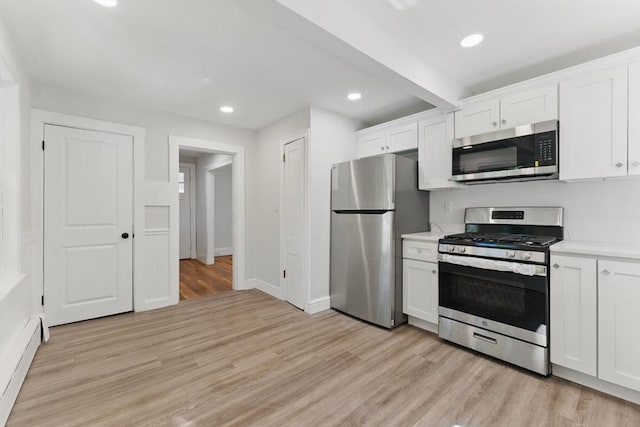 515 Front St, Weymouth, MA 02188 - kitchen featuring appliances with stainless steel finishes, baseboard heating, light wood-style floors, white cabinets, and recessed lighting