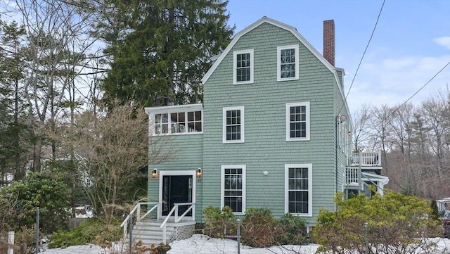 view of front of property featuring a chimney and a gambrel roof