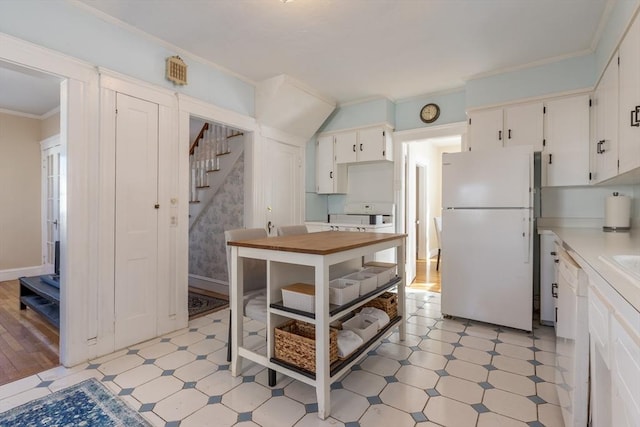 kitchen featuring white appliances, ornamental molding, and white cabinets