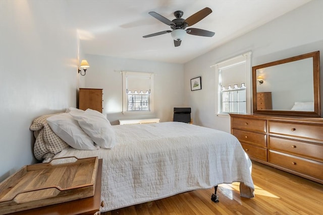 bedroom with multiple windows, ceiling fan, and light hardwood / wood-style flooring