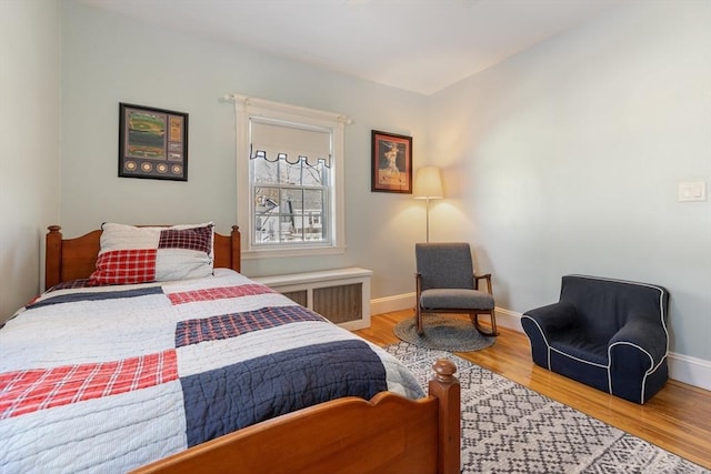 bedroom featuring radiator heating unit and wood-type flooring