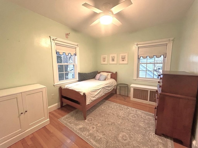 bedroom with radiator, ceiling fan, and light hardwood / wood-style floors