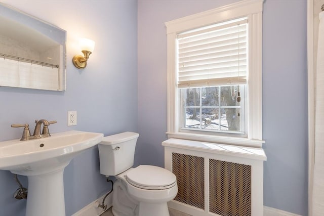 bathroom featuring sink, a wealth of natural light, radiator heating unit, and toilet