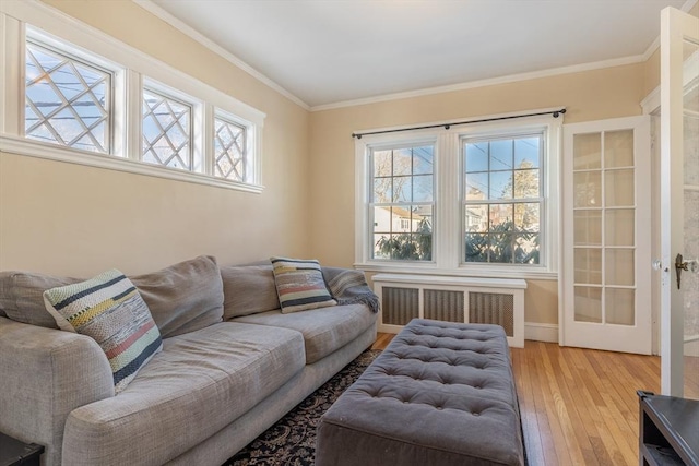 living room with ornamental molding, radiator, and light hardwood / wood-style floors