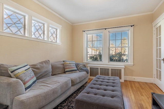 living room featuring crown molding, radiator heating unit, and light wood-type flooring