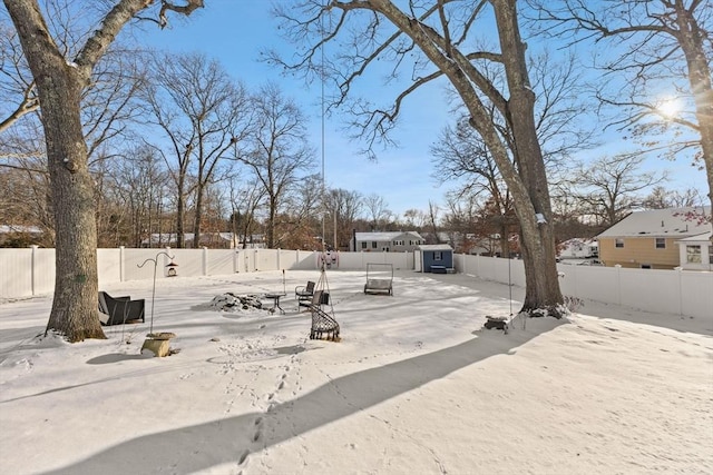 yard covered in snow with a shed