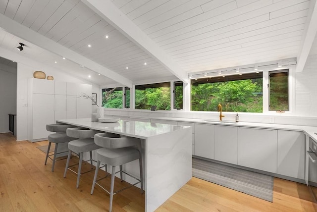 86 Myles Standish Rd, Weston, MA 02493 - kitchen with a sink, modern cabinets, white cabinetry, a center island, and light wood-type flooring