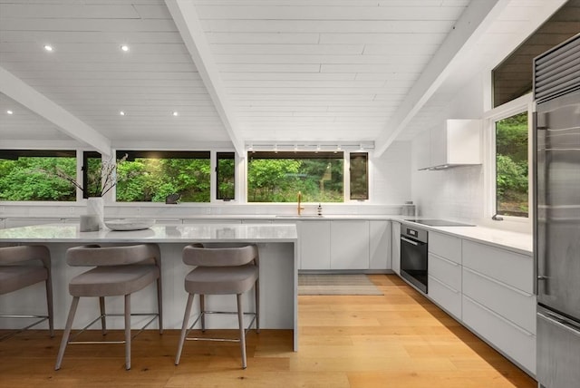 86 Myles Standish Rd, Weston, MA 02493 - kitchen featuring modern cabinets, oven, beamed ceiling, white cabinets, and light wood-style floors