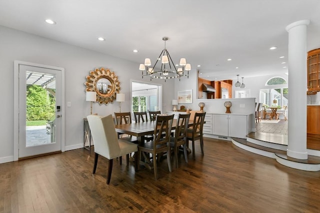 dining space with decorative columns, a chandelier, a healthy amount of sunlight, and dark hardwood / wood-style floors