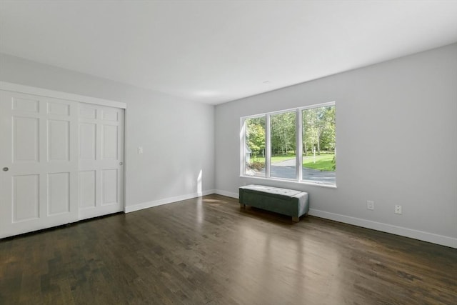 unfurnished bedroom with a closet and dark hardwood / wood-style floors