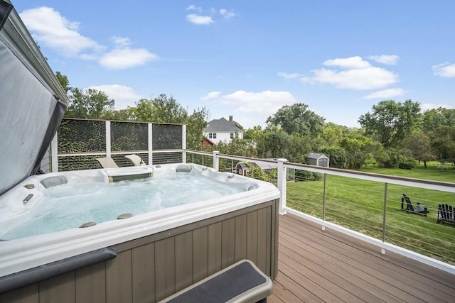 deck with a shed, a yard, and a hot tub