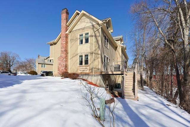 snow covered property with a deck