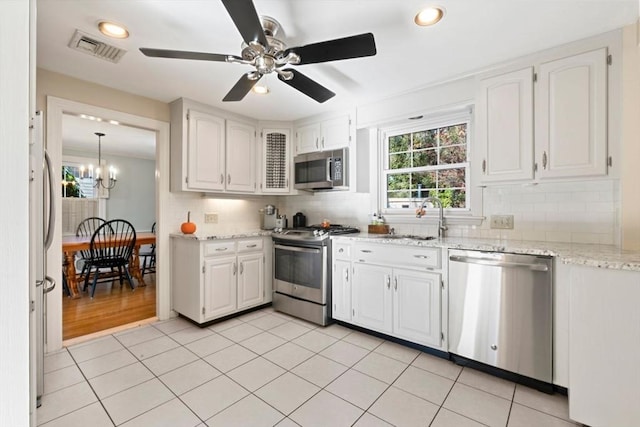 kitchen with white cabinets, backsplash, sink, and appliances with stainless steel finishes