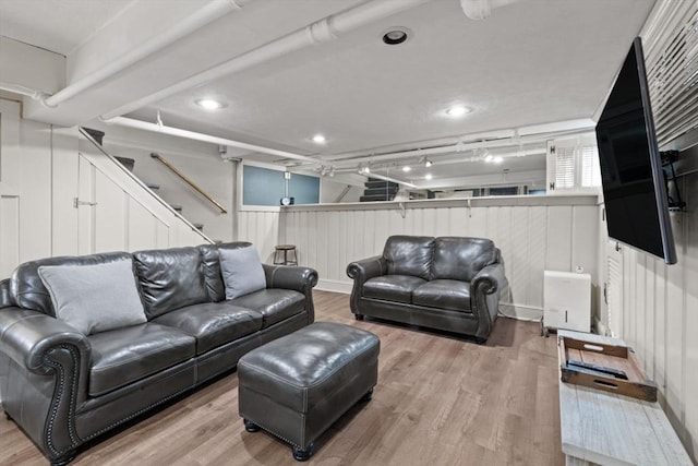 living room featuring wood walls and light wood-type flooring