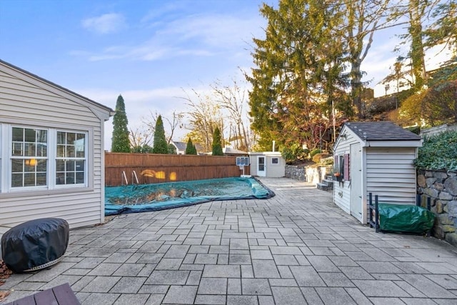 view of patio / terrace featuring a covered pool and a storage shed