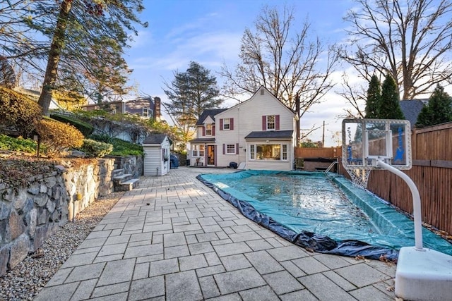 view of swimming pool with a patio area and a shed