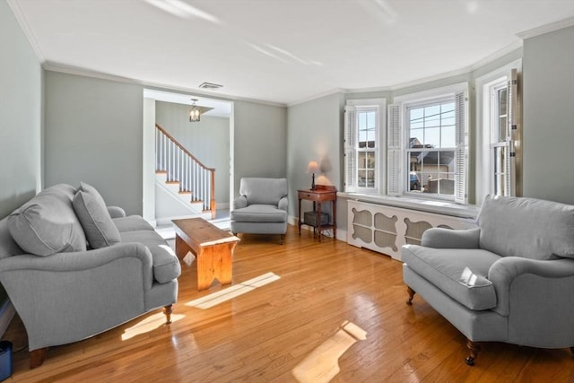 living room featuring light hardwood / wood-style flooring and crown molding