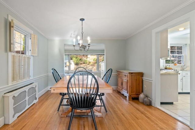 dining room featuring a chandelier, crown molding, and light hardwood / wood-style flooring