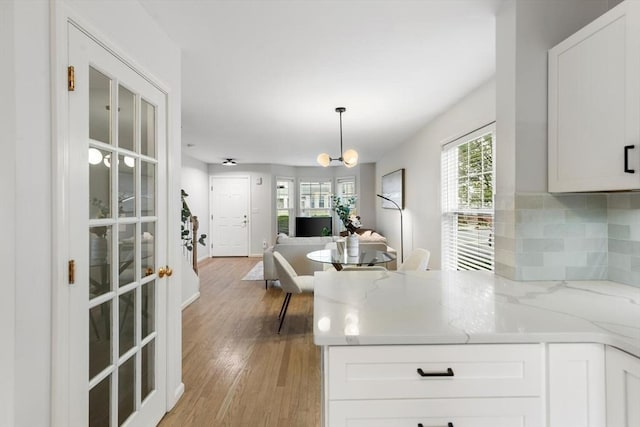32 Pearl St Unit 32, Everett, MA 02149 - kitchen featuring light wood finished floors, white cabinetry, a peninsula, and open floor plan
