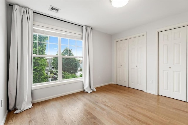 32 Pearl St Unit 32, Everett, MA 02149 - unfurnished bedroom featuring light wood-type flooring and multiple closets
