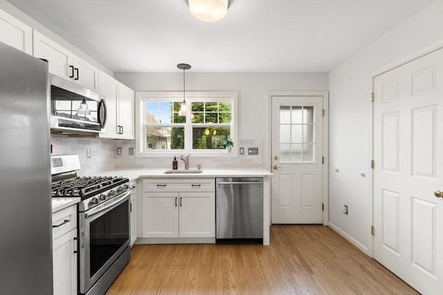 32 Pearl St Unit 32, Everett, MA 02149 - kitchen with appliances with stainless steel finishes, tasteful backsplash, light countertops, and light wood-style floors