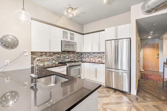 kitchen with light parquet floors, sink, white cabinets, and appliances with stainless steel finishes