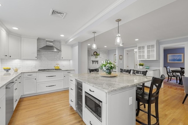 kitchen featuring a breakfast bar area, stainless steel appliances, recessed lighting, and visible vents