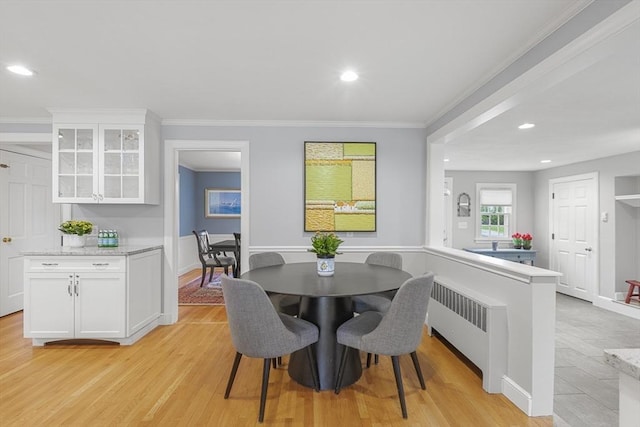 dining room featuring light wood-style floors, recessed lighting, ornamental molding, and radiator